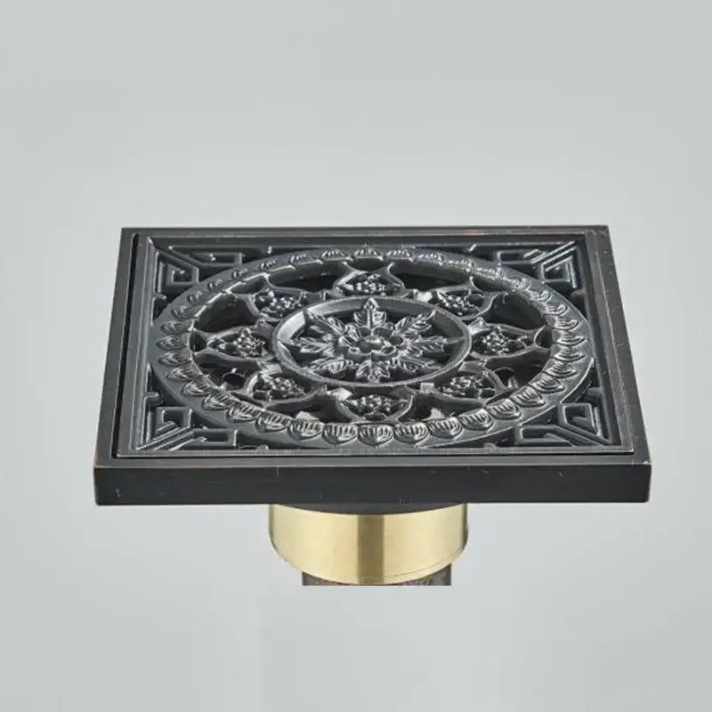 DecorBites antique brass floor drain with black matte finish and square fish carved floral embossed pattern on brass base