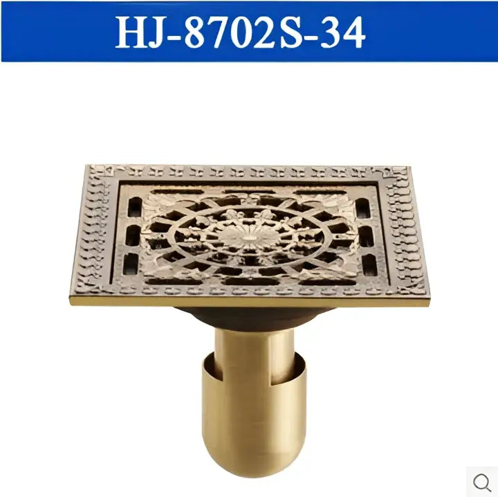 Brass-colored antique brass square floor drain with intricate floral pattern and central circular design by decorbites