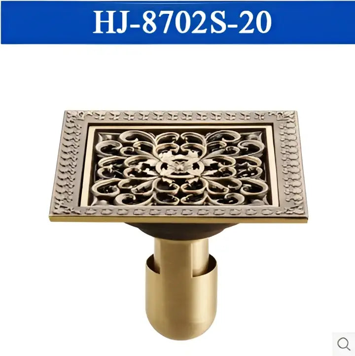 Brass-colored antique brass square floor drain with ornate floral pattern and decorative border for shower use
