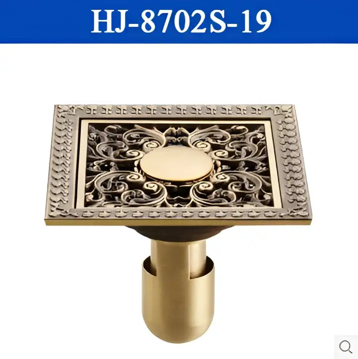 Decorbites antique brass square floor drain strainer grate with ornate scrollwork and central circular medallion