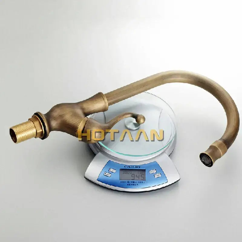 DecorBites antique brass swivel basin mixer tap with curved spout and decorative handle in brass finish