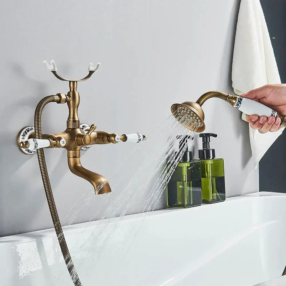Decorbites™ antique brass telephone shape wall mounted bathtub faucet with ornate handles and matching handheld showerhead