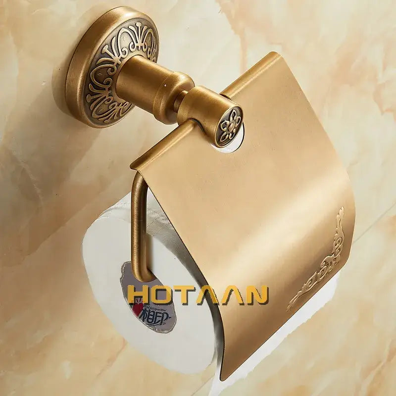 Brass toilet paper holder with ornate floral detailing and curved design in antique brass for classic bathroom use