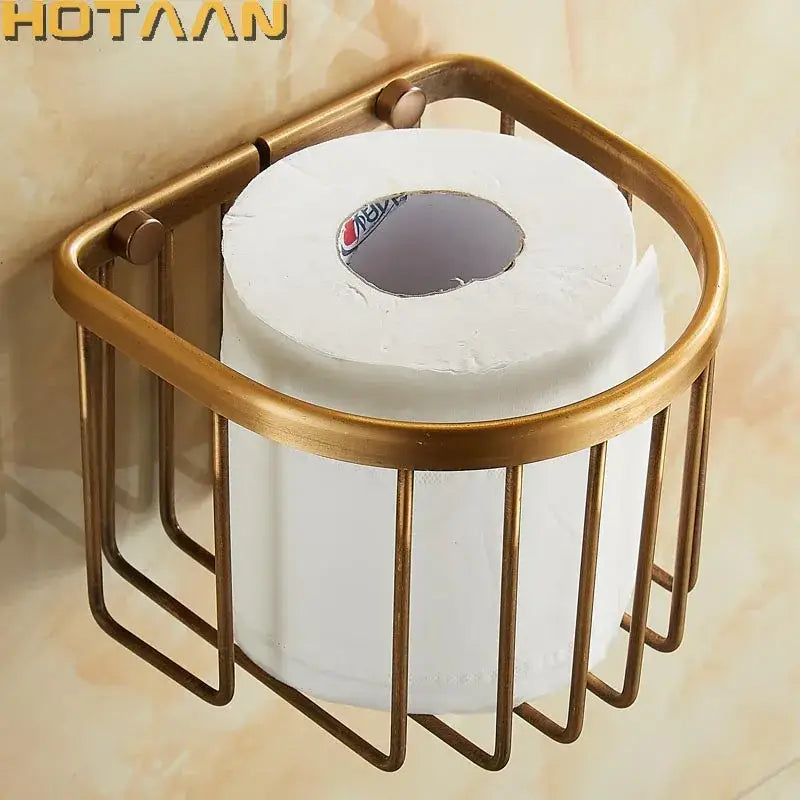 Brass-colored antique brass toilet paper holder with cylindrical wireframe design holding standard white roll