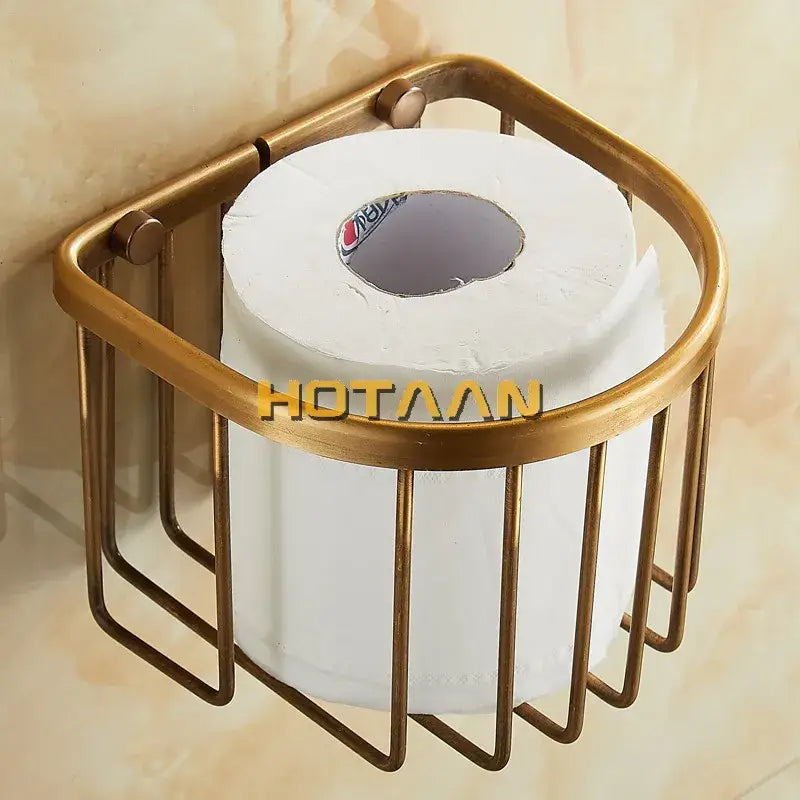 Brass-toned antique brass toilet paper holder with cylindrical wireframe design holding a white roll for wall mounting