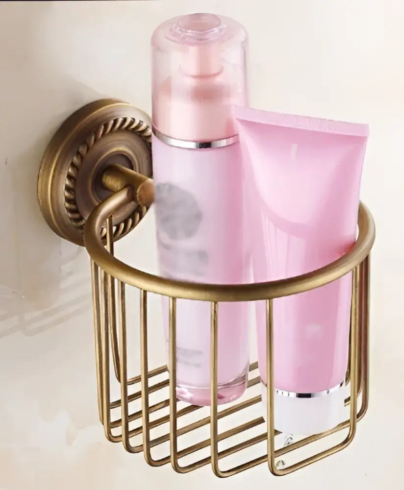 DecorBites antique brass toilet paper holder wall mount with wire mesh caddy holding pink skincare products
