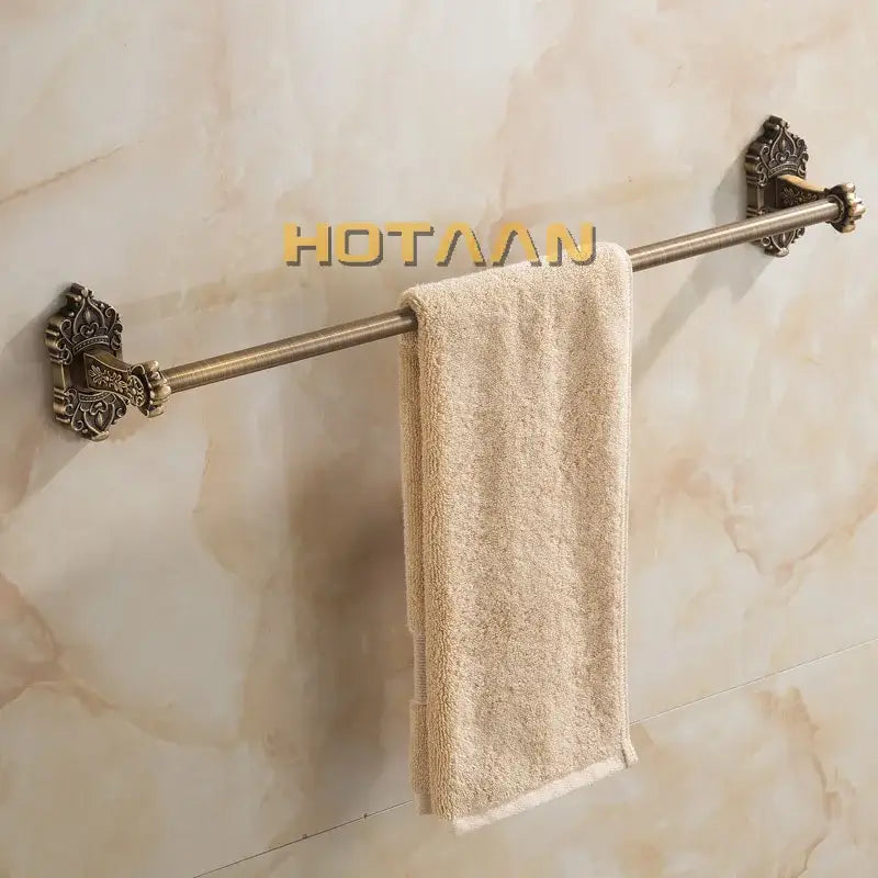 Decorbites antique brass towel bar wall mounted brass towel bar with ornate ends holding beige terry cloth towel