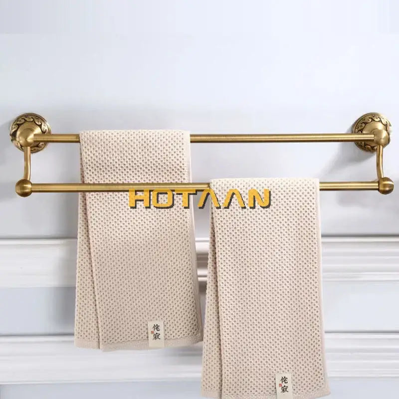 Beige textured towel with subtle woven pattern displayed on decorbites™ antique brass single bar towel holder rack