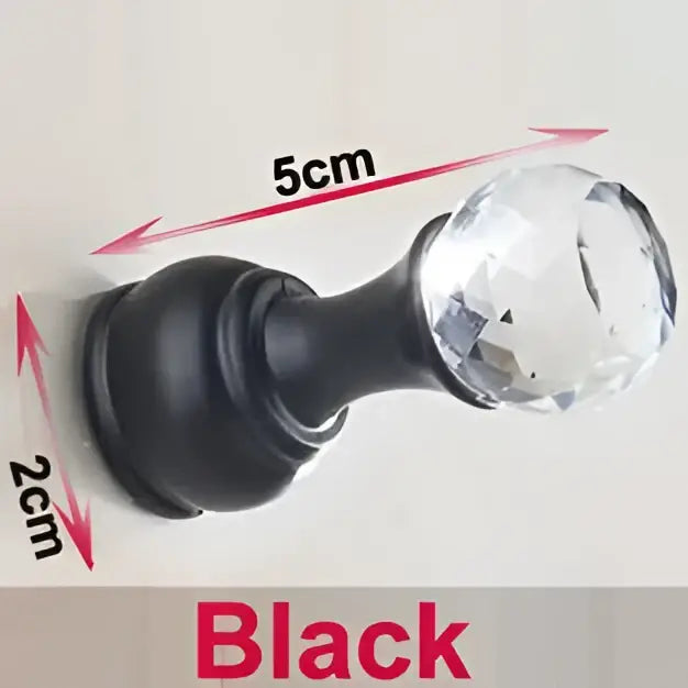 Black crystal knob with faceted clear glass head and matte black base on DecorBites antique brass wall clothes rack