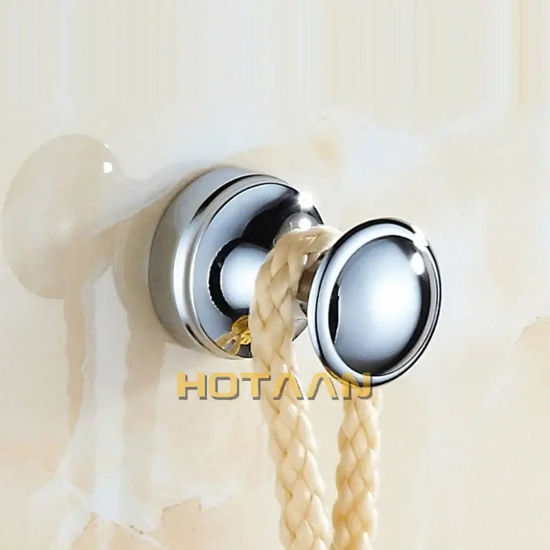 Chrome-finished double hook with a sleek rounded design and beige braided rope on decorbites™ antique brass wall robe hanger