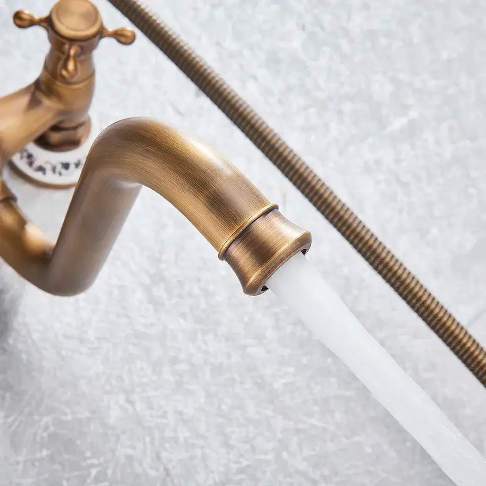 Antique brass shower mixer tap with curved spout, cross-handle, and flexible braided hose for wall mount use