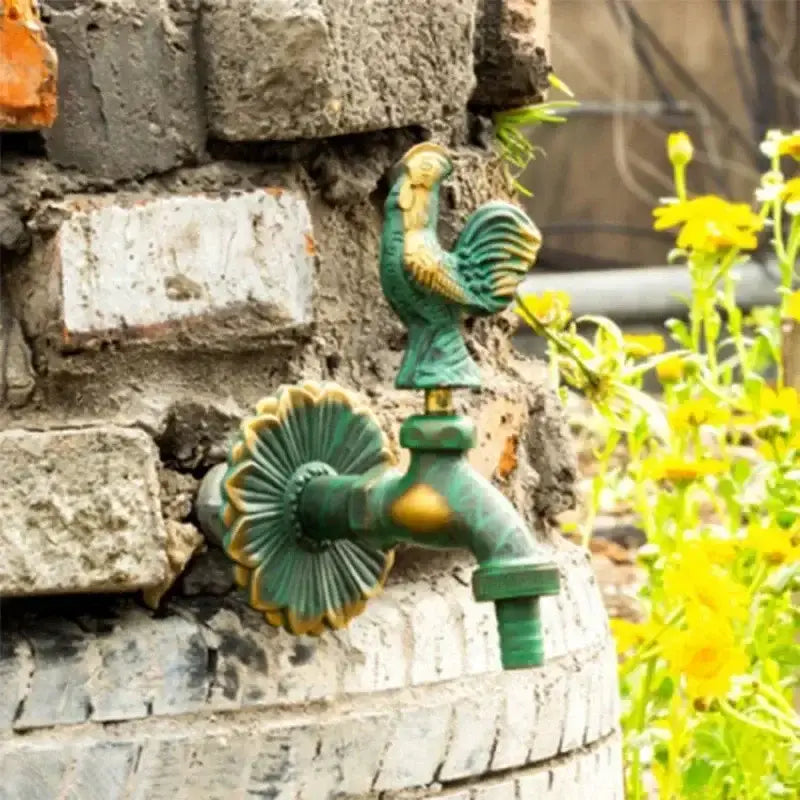 DecorBites™ antique brass wall mount garden faucet in green and gold with a rooster-themed ornate fluted design