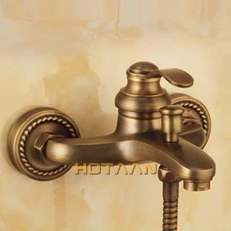 Decorbites antique brass wall mount shower head kit with antique brass faucet and ornate rope detailing on mounting plates