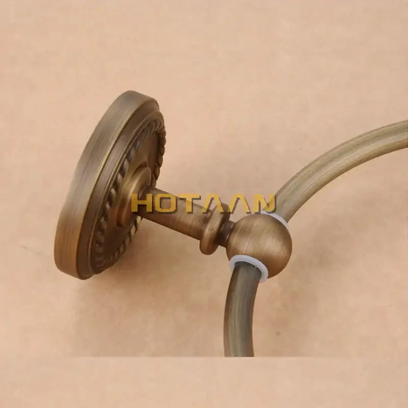 Decorbites antique brass towel ring holder with ornate circular base and curved arm for wall-mounted use