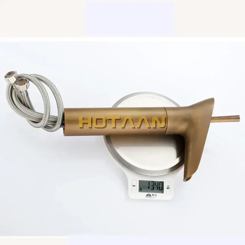 Bronze-finished decorbites antique brass waterfall basin faucet with sleek design and coiled stainless steel hose mixer tap