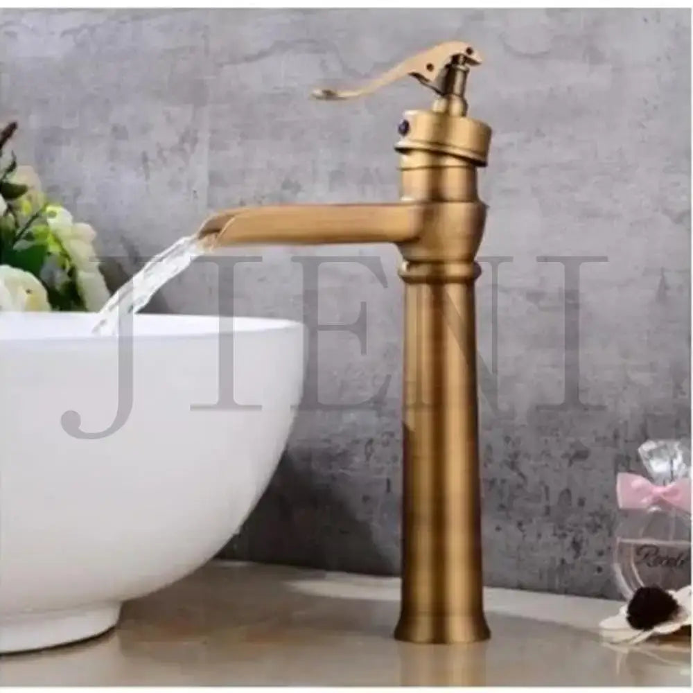 DecorBites™ antique brass waterfall basin faucet with a tall cylindrical spout and ornate art design handle