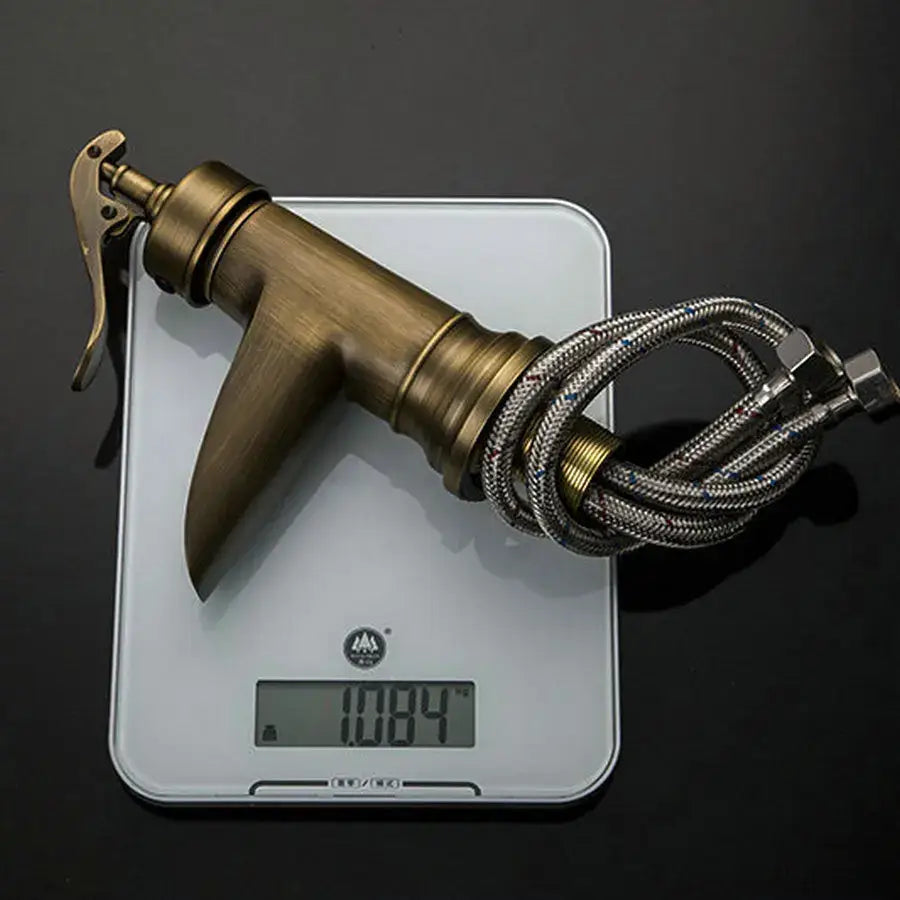 DecorBites™ antique brass waterfall basin faucet with art design handle and coiled stainless steel hose for bathroom use