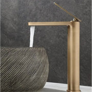 Decorbites™ antique bronze basin faucet featuring a brass finished modern waterfall spout and tall cylindrical body