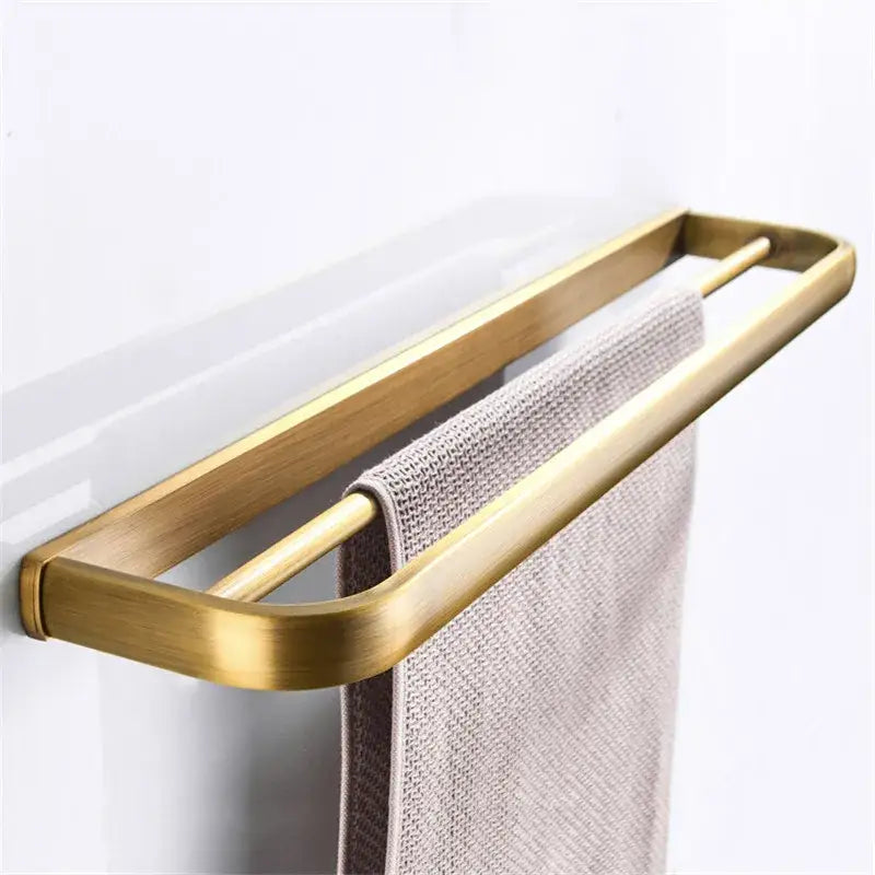 Gold-toned double-bar towel rack with brushed metallic finish in DecorBites antique bronze bathroom accessory set