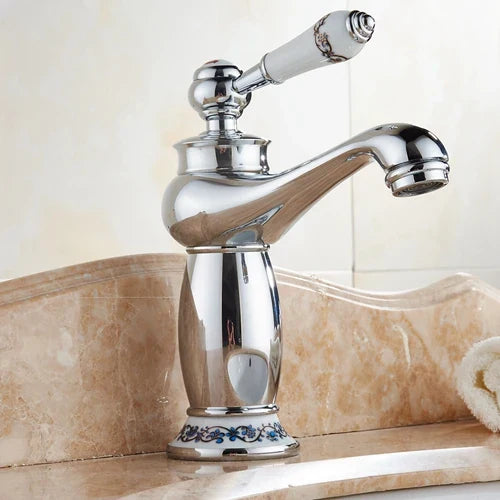 Antique bronze decorbites single handle bathroom faucet with chrome finish white ceramic handle and blue floral detailing real shot details