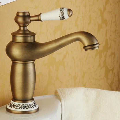 Antique bronze DecorBites™ single handle bathroom faucet with brass finish and white ceramic base with black floral patterns real shot details
