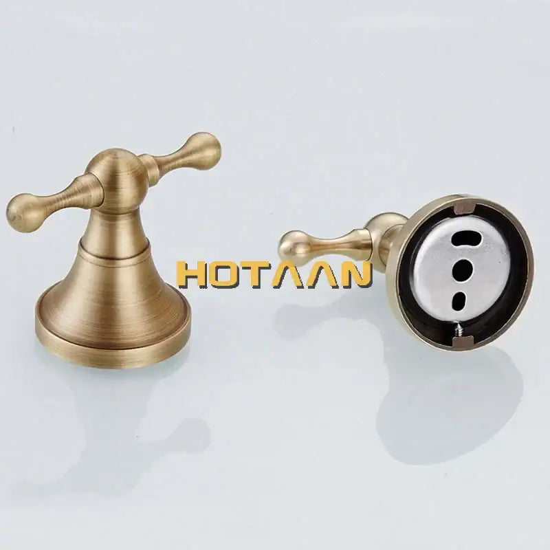 Antique bronze brass bathroom faucet handles with ornate cross-shaped levers complement bronze brass wall hooks decor