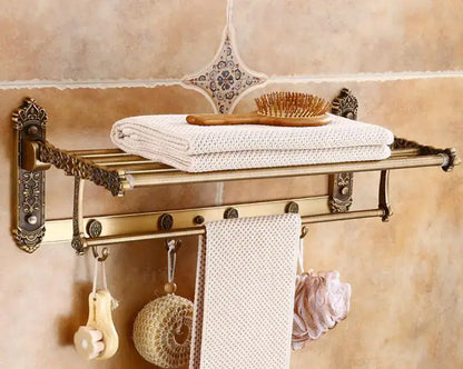 Decorbites antique bronze carved aluminum towel rack with ornate scrollwork holding white textured towels