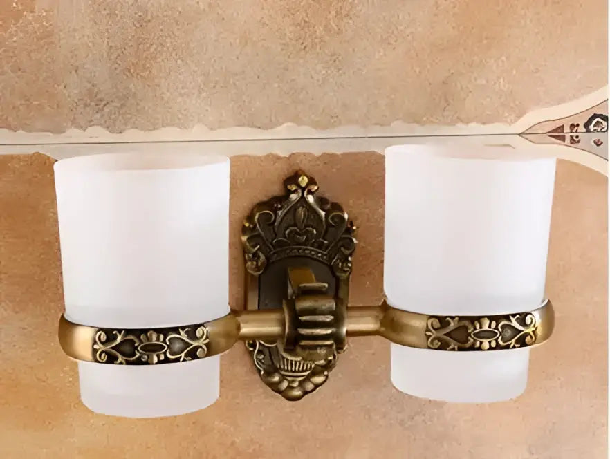 Antique bronze carved aluminum wall-mounted toothbrush holder with two frosted cups and ornate decorative centerpiece