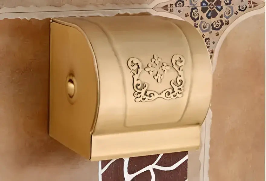 Gold-colored ornate metal toilet paper holder with floral embossing from DecorBites™ antique bathroom accessories set