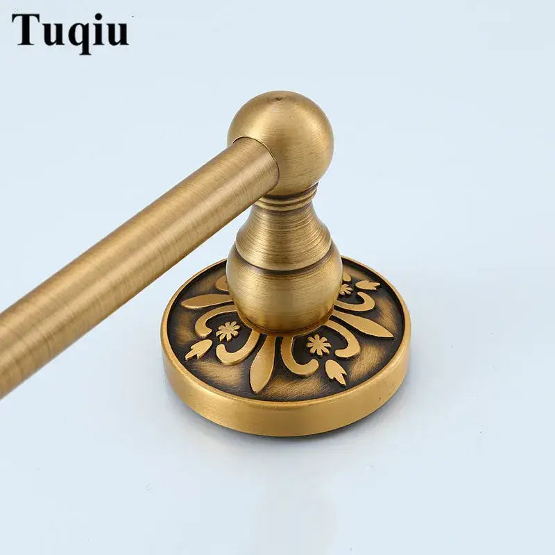 Antique brass-finished towel rack with ornate floral engraving on circular base from decorbites bathroom accessories set