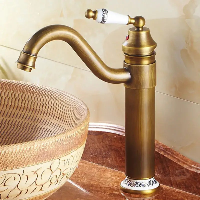 Antique bronze finish decorbites bathroom sink faucet with single white ceramic handle and black floral detailing