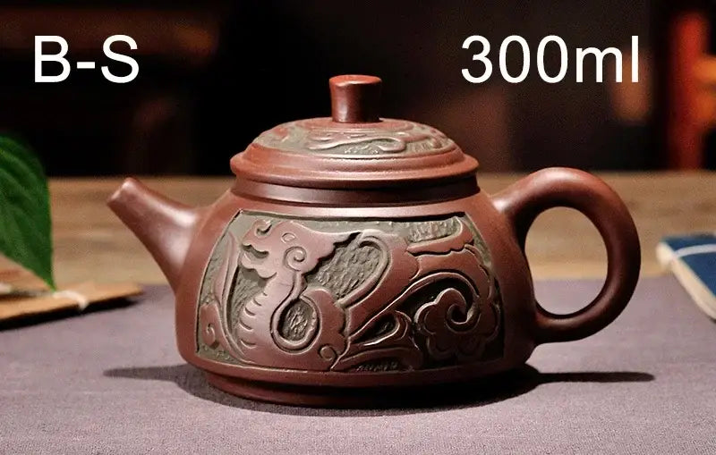 A rich terracotta yixing clay teapot set with antique bronze teapot design featuring embossed dragon and cloud motifs