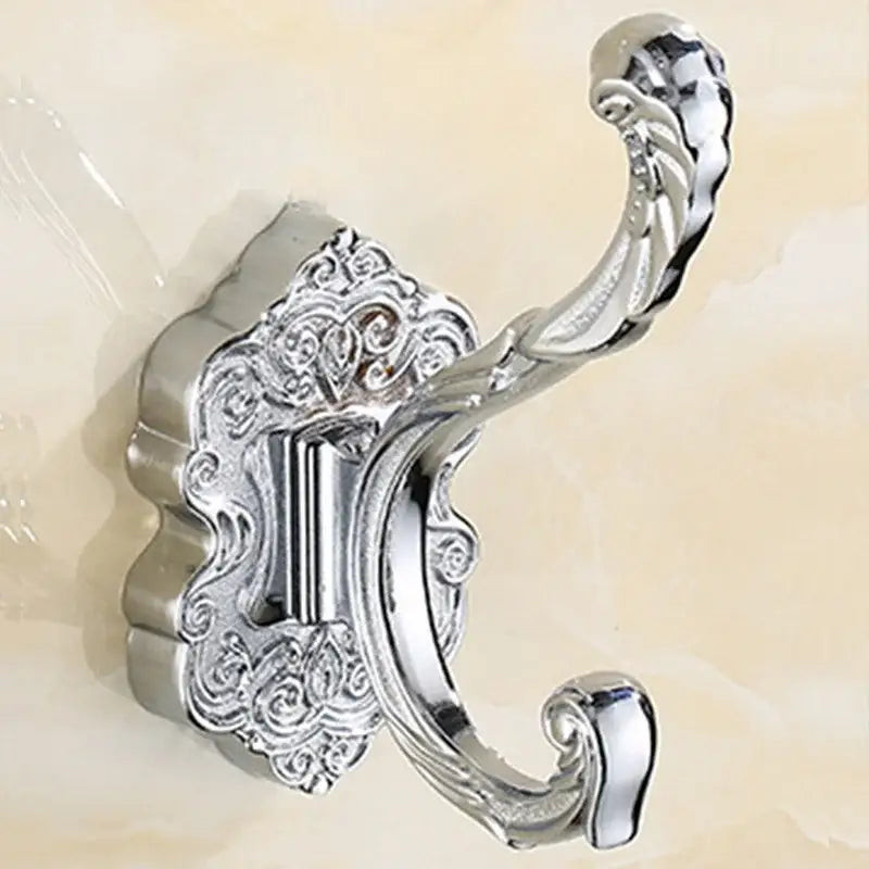 Chrome-plated metal wall hook with ornate scrollwork and curved loop for clothes in antique bronze wall hook style