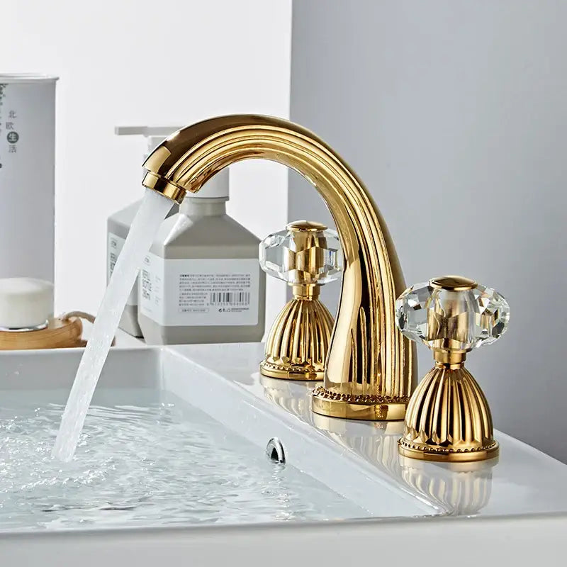 Decorbites antique bronze widespread basin faucet with gold finish crystal knobs and ornate fluted detailing on base