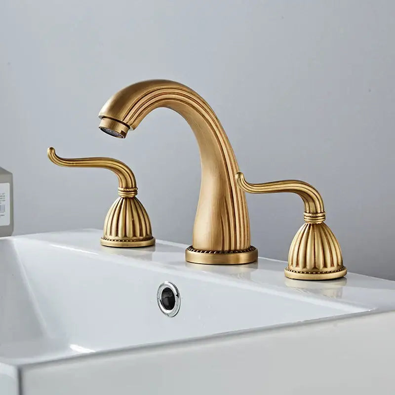 Decorbites antique bronze widespread basin faucet with gold-toned ornate fluted handles and curved spout