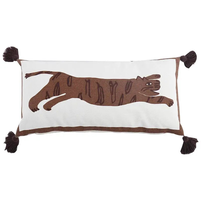 White rectangular pillow cover with antique brown tiger print embroidery and matching tassels at each corner by DecorBites