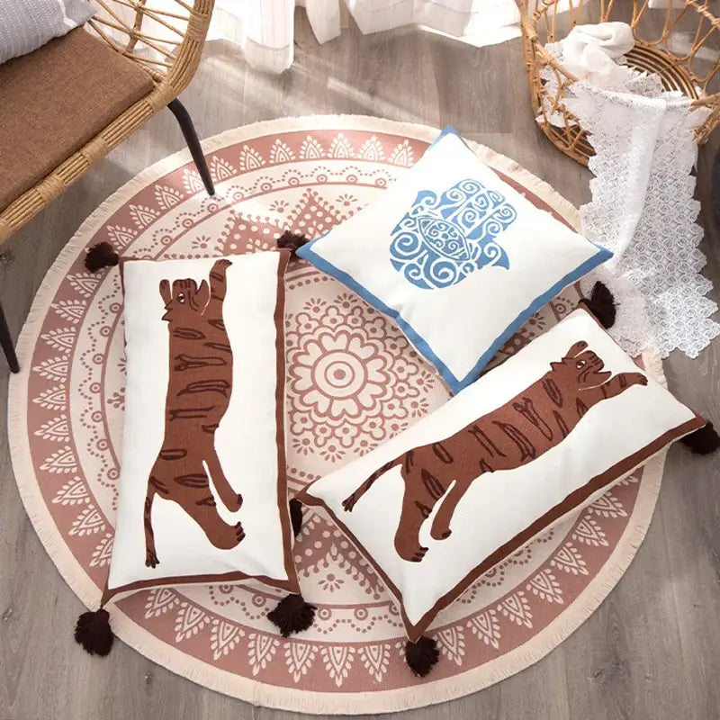 White rectangular pillow cover with antique brown tiger print, blue embroidery, and dark brown tassels by DecorBites™