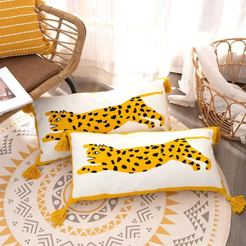 Two rectangular white pillow covers with embroidered antique brown tiger print and mustard-yellow tassels by DecorBites™