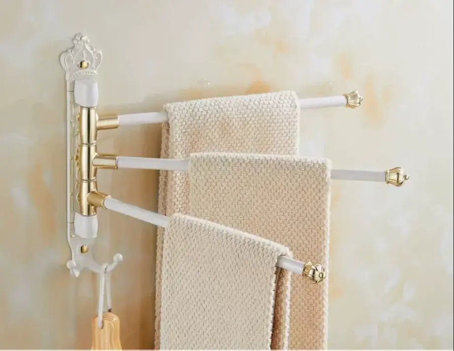 White and gold ornate antique carved swivel towel rack with three extendable arms holding beige textured towels