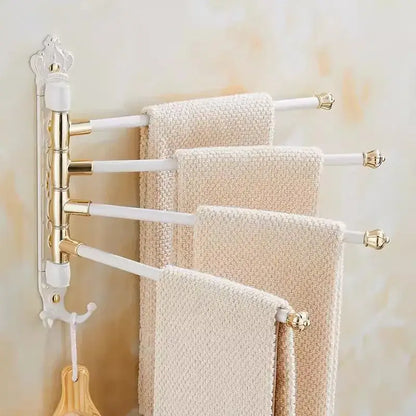 White and gold ornate antique carved swivel towel rack with four rotating arms holding textured beige towels wall mounted