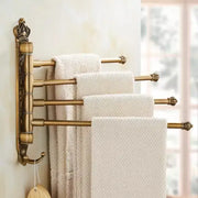 Antique brass DecorBites™ antique carved swivel multi-tiered towel rack with ornate crown and decorative finials