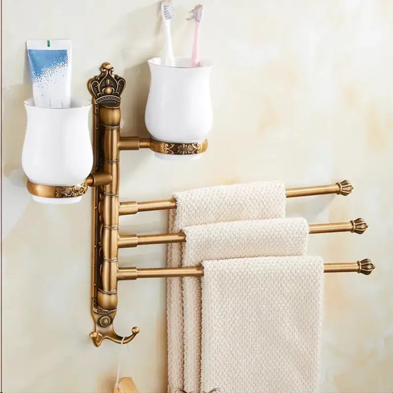 Antique brass-finished DecorBites towel rack with carved swivel towel bars and white ceramic toothbrush holders