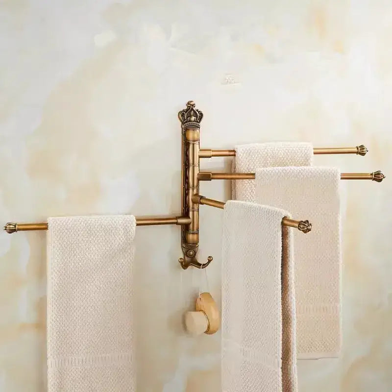 Antique brass DecorBites™ carved swivel towel rack with crown design and three rotating arms holding white towels
