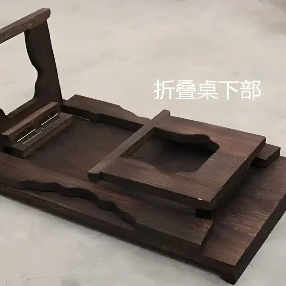 Dark brown solid wood foldable table with carved edges and recessed compartment for hanfu shoots and tea cooking