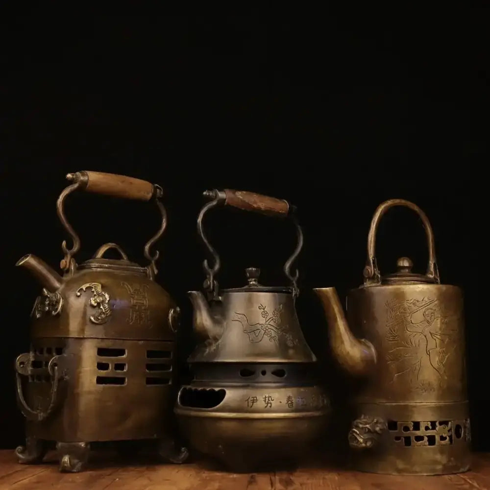 Three antique brass warm wine pots with wooden handles and intricate engraved dragon and floral designs from decorbites