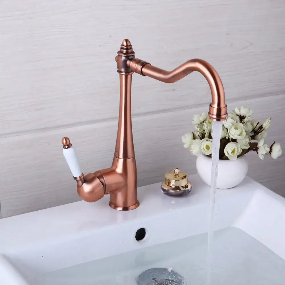 Antique copper basin mixer tap with ceramic handle and ornate curved spout for kitchen use by decorbites