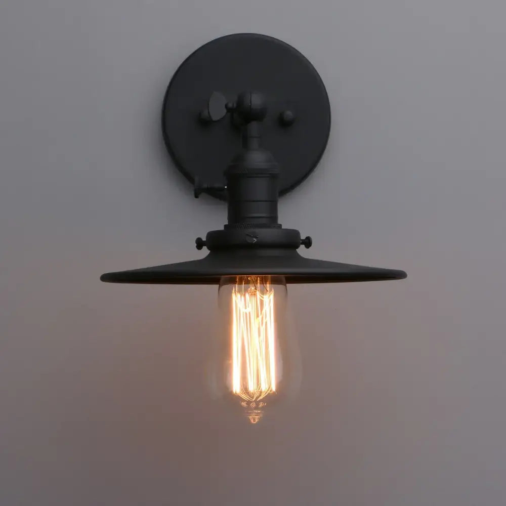 Black industrial wall sconce with antique finish wide flat shade exposed filament bulb and on off button canopy 7.87 inches
