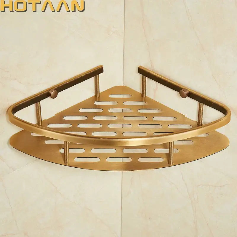 Brass-colored triangular corner shower caddy with antique finish aluminum and perforated design for bathroom organization