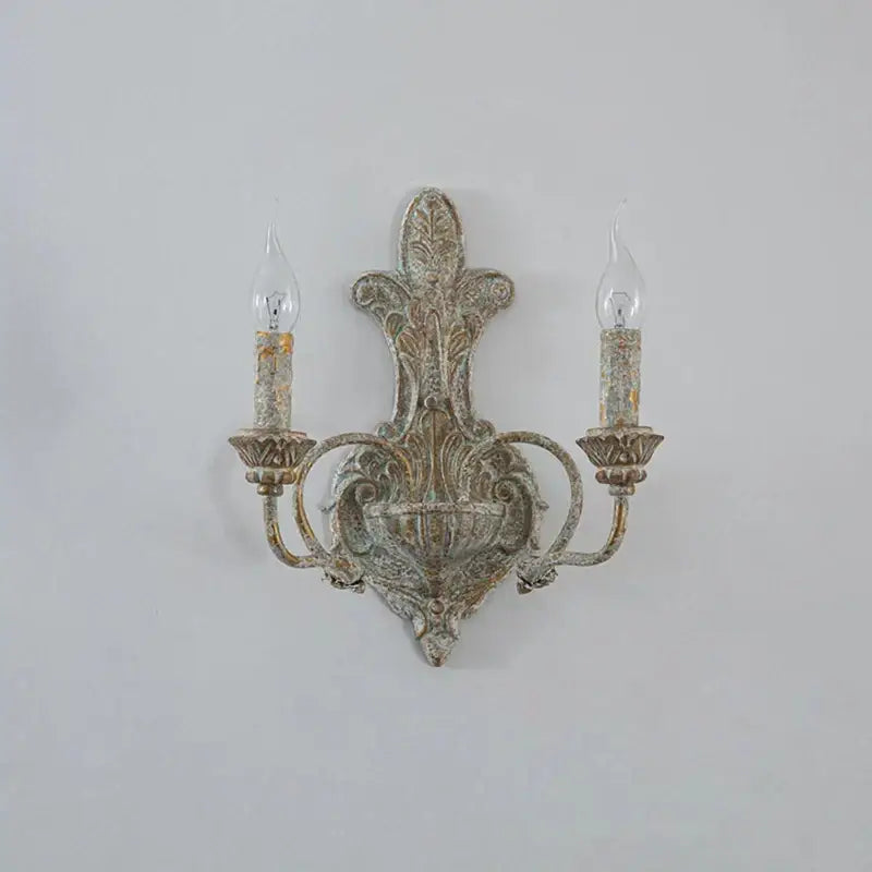 Antique iron double wall lamp by DecorBites with distressed finish and candle-shaped bulbs for retro bedroom use