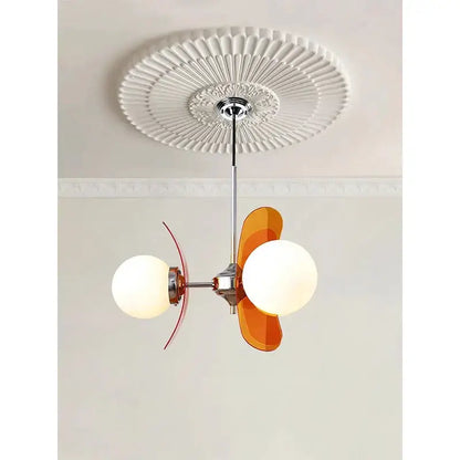 A DecorBites antique style chandelier with chrome arms, frosted glass shades, and orange red panels for living spaces